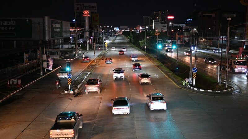 Cars driving down a city street at night