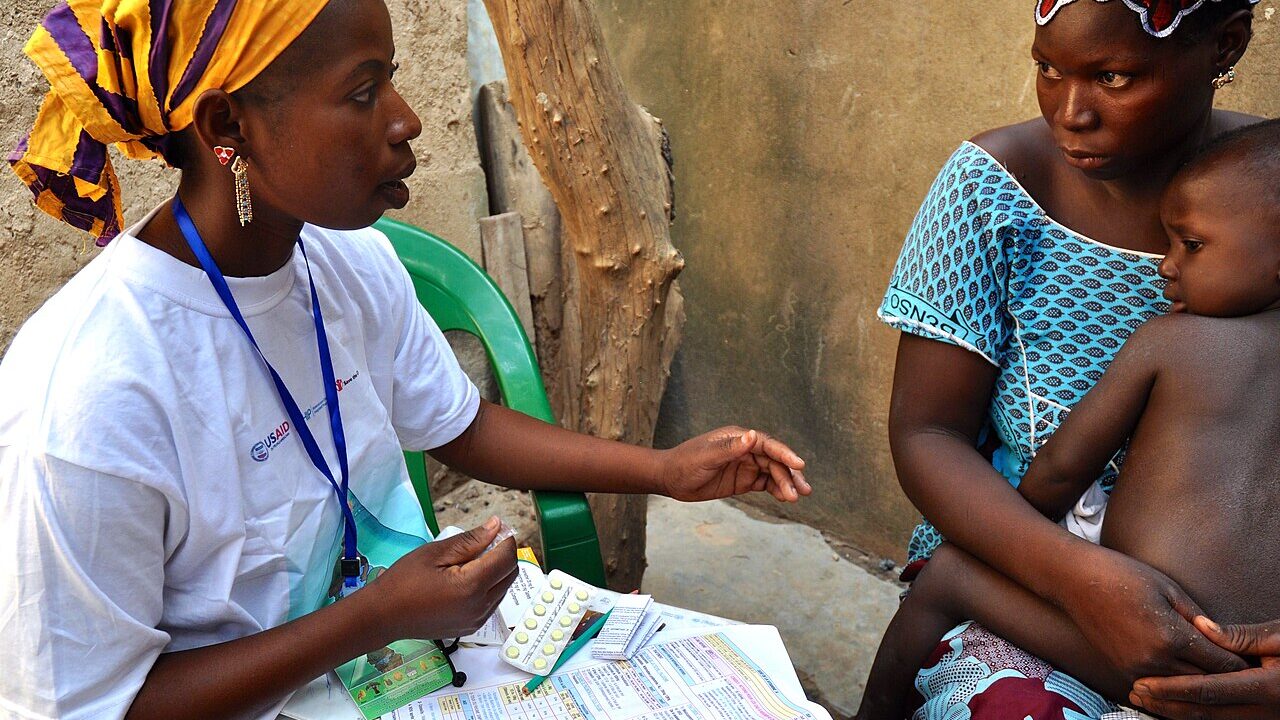 A community health worker examining a child