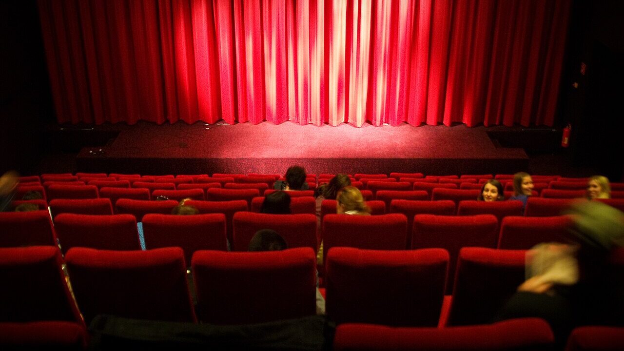 Rows of seats inside a cinema auditorium facing the screen