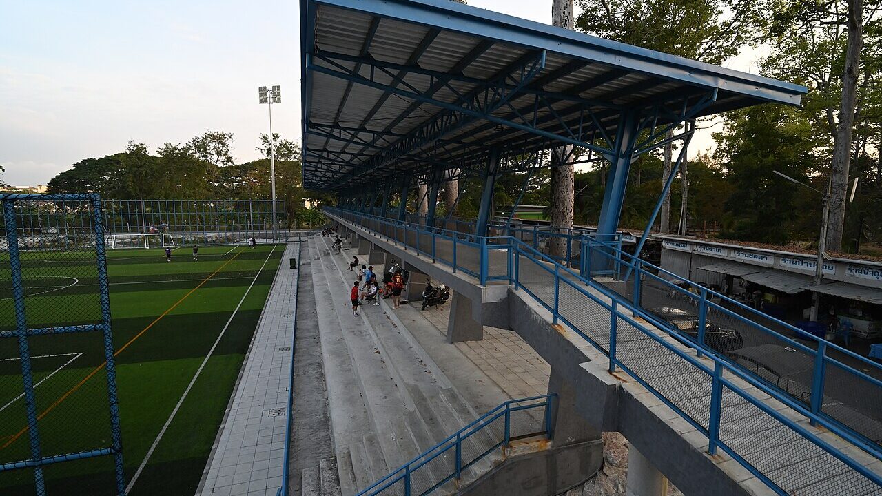 Empty youth soccer field with covered grandstand at dusk