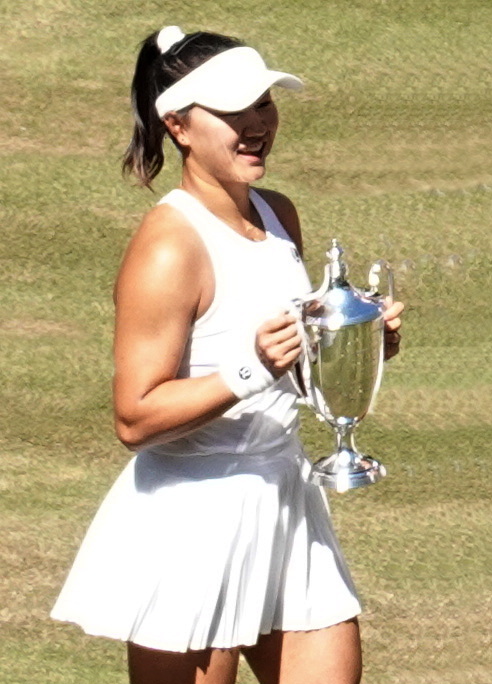 Chinese tennis player Guo Hanyu holding the Wimbledon doubles trophy